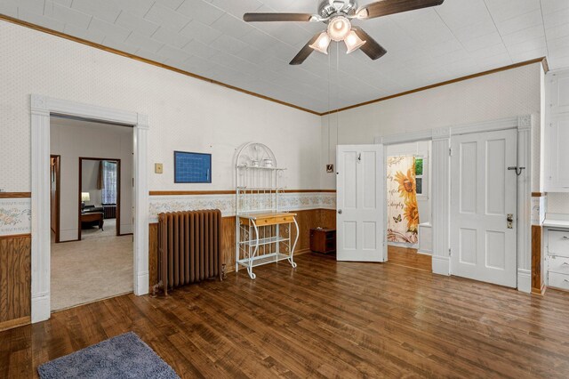 52905 Deerwood Ave, Rush City, MN 55069 - empty room with radiator heating unit, crown molding, wallpapered walls, wood finished floors, and a ceiling fan