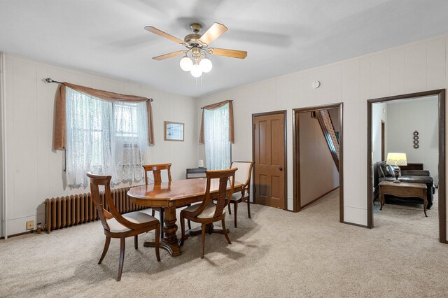 52905 Deerwood Ave, Rush City, MN 55069 - dining space with ceiling fan, light colored carpet, radiator, and a decorative wall