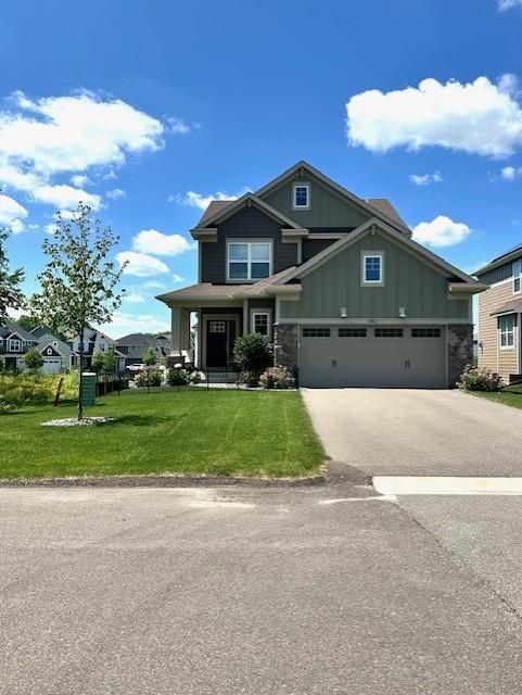 10803 Glacier Ln N, Maple Grove, MN 55369 - craftsman inspired home with board and batten siding, a front lawn, asphalt driveway, a garage, and stone siding