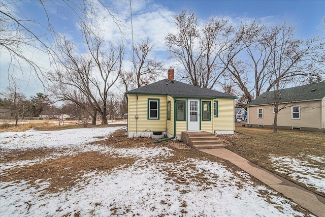 bungalow featuring central air condition unit and a chimney