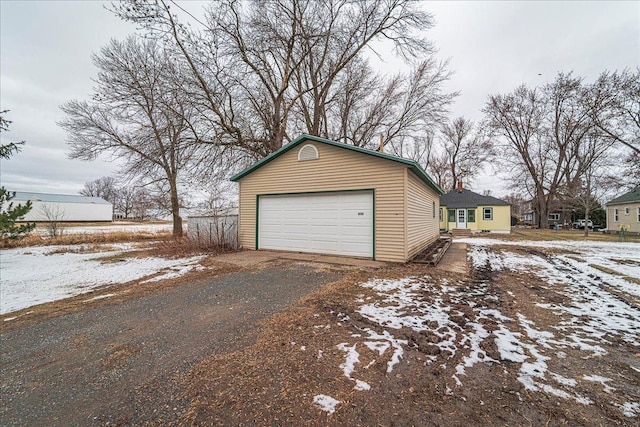 snow covered garage featuring a detached garage
