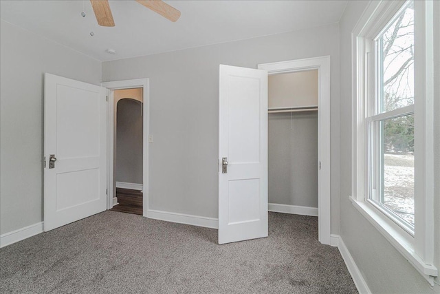 unfurnished bedroom featuring carpet floors, baseboards, a closet, and ceiling fan