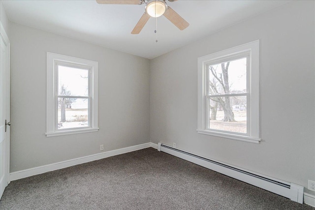 empty room with ceiling fan, a baseboard heating unit, a healthy amount of sunlight, and dark colored carpet