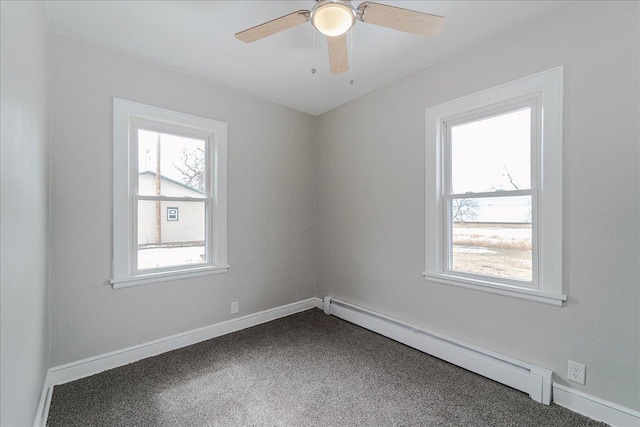 spare room featuring baseboards, a baseboard heating unit, ceiling fan, and dark colored carpet