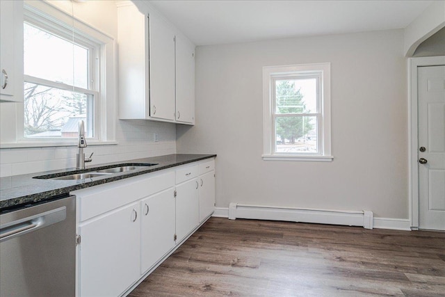 kitchen with decorative backsplash, baseboard heating, dishwasher, a sink, and white cabinetry