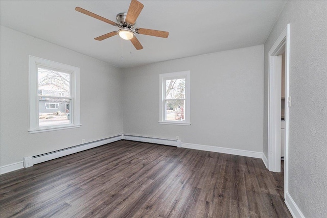 spare room with baseboard heating, a ceiling fan, baseboards, a baseboard radiator, and dark wood-style floors