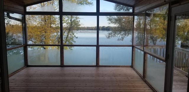 unfurnished sunroom featuring a water view