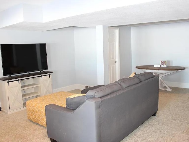 living area with baseboards and light colored carpet
