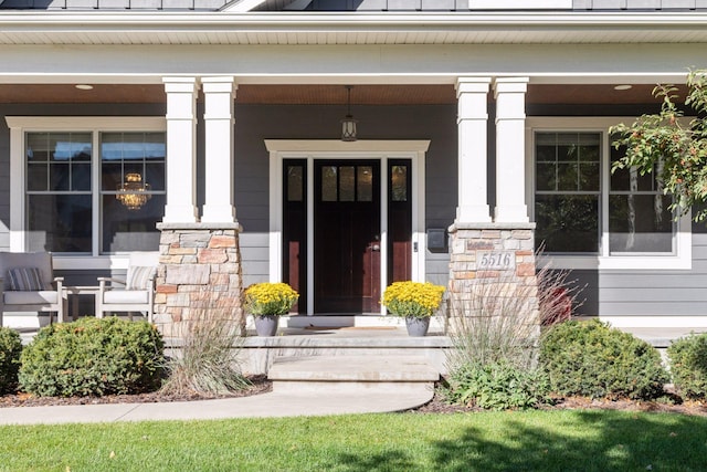 view of exterior entry featuring a porch and stone siding