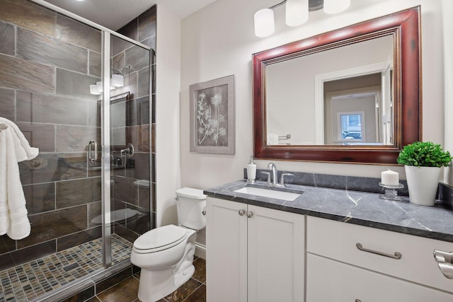 full bath featuring vanity, toilet, and a shower stall