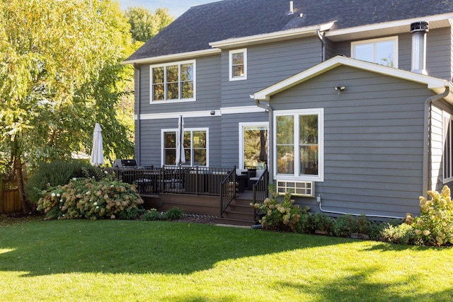 rear view of property featuring a lawn and a wooden deck