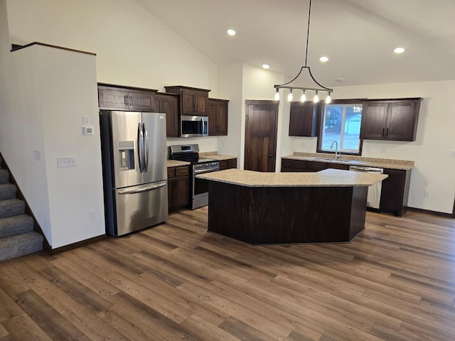 10815 190th Ln NW, Elk River, MN 55330 - kitchen with dark brown cabinets, a center island, a sink, dark wood finished floors, and appliances with stainless steel finishes