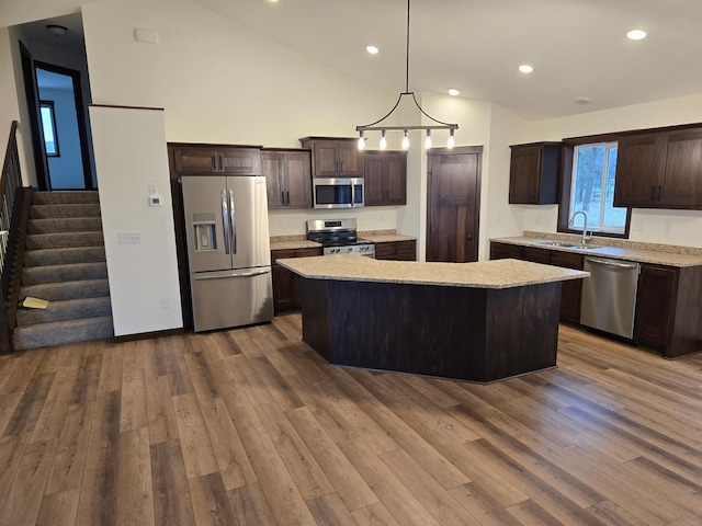 10815 190th Ln NW, Elk River, MN 55330 - kitchen with dark brown cabinets, a center island, dark wood-type flooring, a sink, and stainless steel appliances