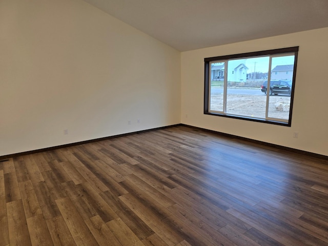 10815 190th Ln NW, Elk River, MN 55330 - spare room with baseboards, vaulted ceiling, and dark wood-type flooring