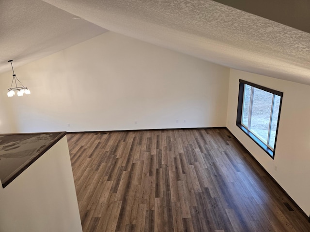 10815 190th Ln NW, Elk River, MN 55330 - additional living space featuring visible vents, a textured ceiling, lofted ceiling, and dark wood-style floors