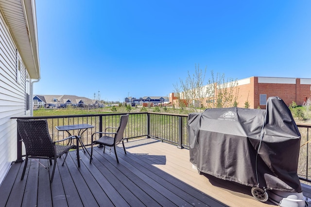 wooden deck featuring a residential view and a grill
