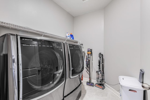 laundry area with laundry area, baseboards, tile patterned floors, and separate washer and dryer