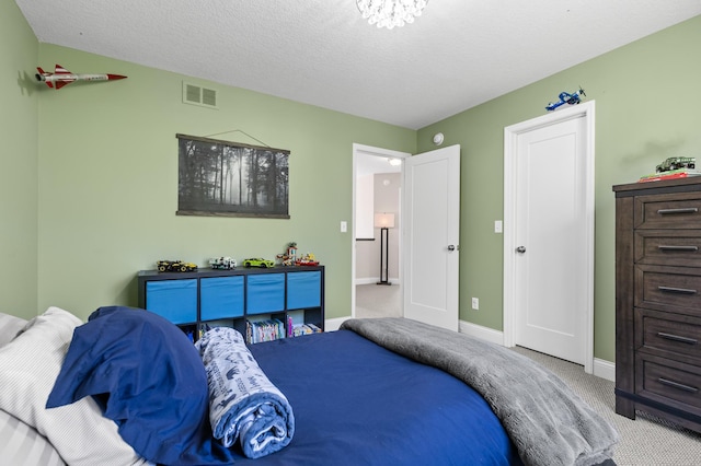 carpeted bedroom featuring baseboards and a textured ceiling