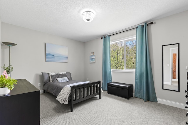 bedroom with light colored carpet, a textured ceiling, and baseboards