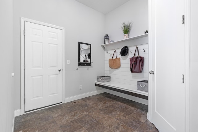 mudroom with baseboards and stone finish floors