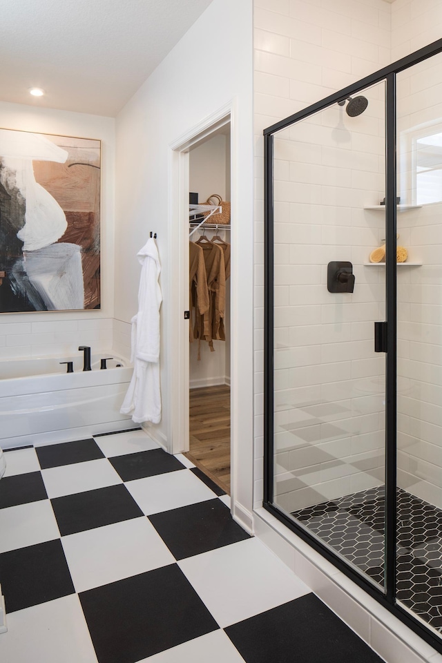 full bath with tile patterned floors, a shower stall, a spacious closet, and recessed lighting