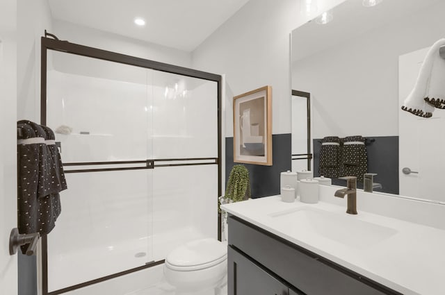 bathroom with a stall shower, toilet, and vanity