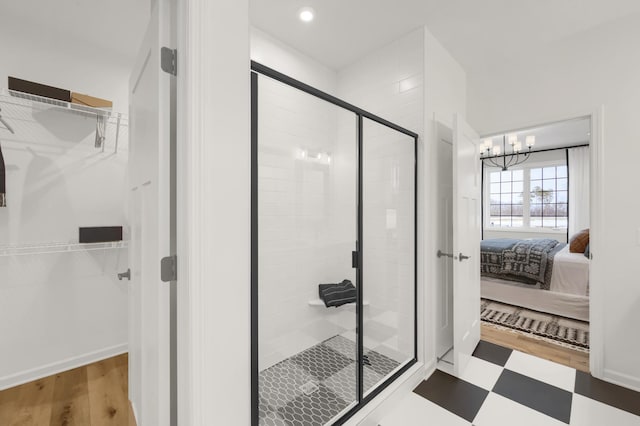 bathroom with a shower stall, ensuite bath, tile patterned floors, and a walk in closet