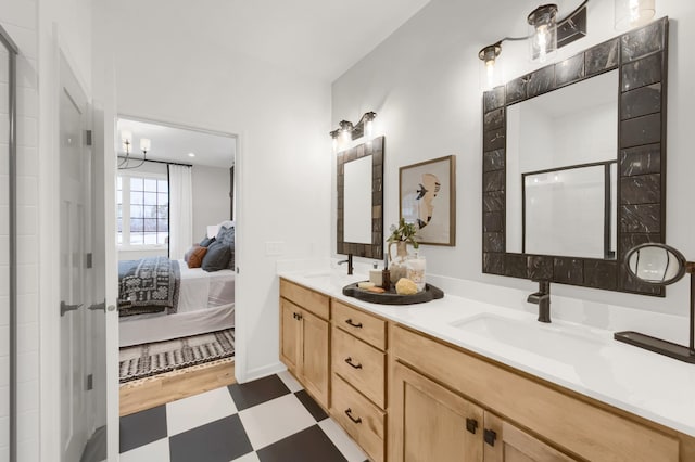 ensuite bathroom with tile patterned floors, a tile shower, and double vanity