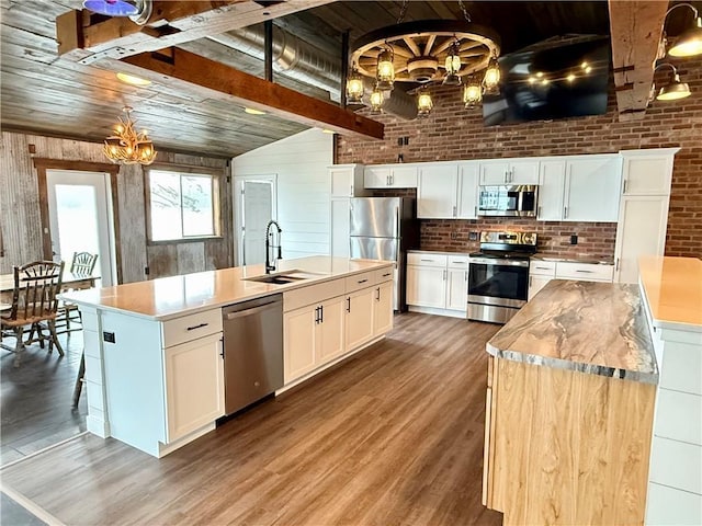 kitchen with a spacious island, wood ceiling, a chandelier, a sink, and appliances with stainless steel finishes