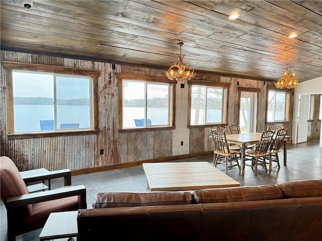 living room featuring baseboards, wood ceiling, a notable chandelier, and wooden walls