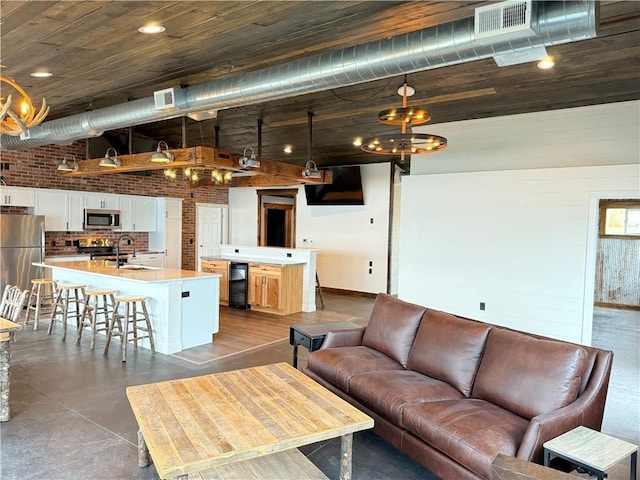 living room with visible vents, a high ceiling, and a chandelier