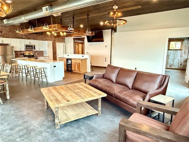 living room with finished concrete floors, baseboards, and visible vents