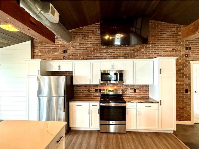 kitchen featuring wooden ceiling, stainless steel appliances, light wood finished floors, and lofted ceiling