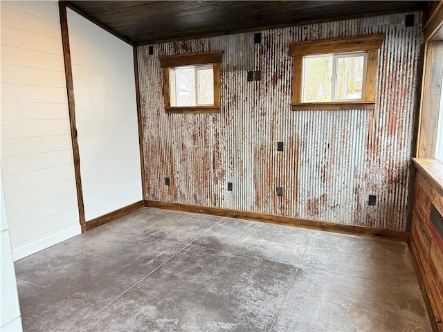 unfurnished room with wooden walls, baseboards, and wood ceiling