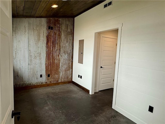 unfurnished room featuring wooden walls, visible vents, wooden ceiling, and electric panel