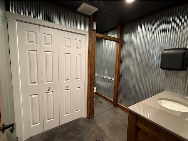 bathroom featuring vanity, concrete flooring, toilet, and visible vents