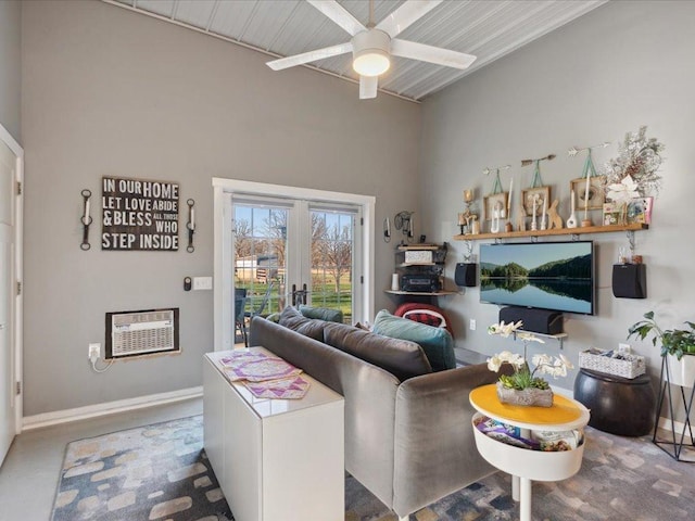 living area with ceiling fan, baseboards, french doors, and a wall mounted AC