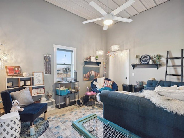 living area with ceiling fan, beam ceiling, a chandelier, and a high ceiling