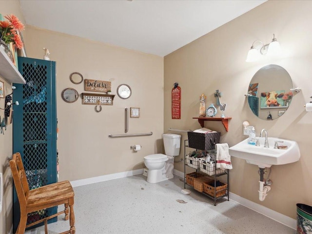 bathroom with toilet, baseboards, and speckled floor
