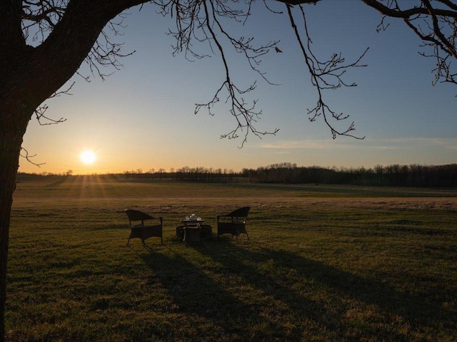 view of property's community featuring a lawn and a rural view