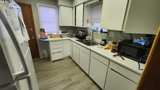 1110 Oakland Ave, Austin, MN 55912 - kitchen featuring black microwave, a sink, light wood-style flooring, and light countertops