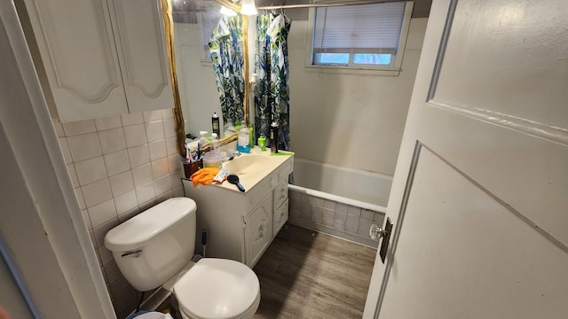 1110 Oakland Ave, Austin, MN 55912 - full bathroom with wood finished floors, toilet, vanity, shower / bath combination with curtain, and tile walls