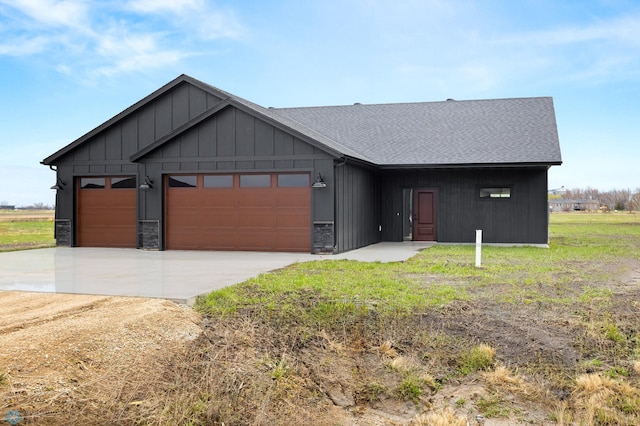 view of front of house with a garage, stone siding, a shingled roof, board and batten siding, and concrete driveway