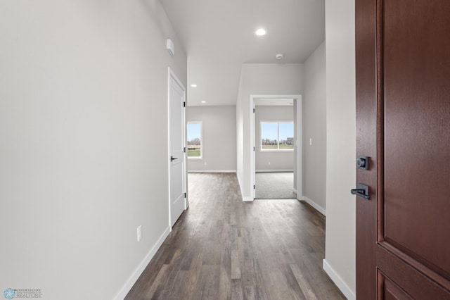 corridor featuring baseboards, recessed lighting, and dark wood finished floors