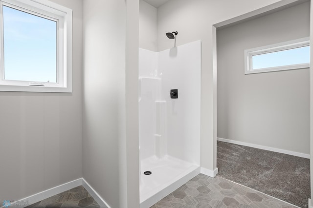 bathroom featuring a walk in shower and baseboards