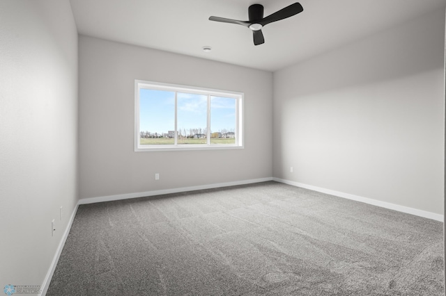 carpeted spare room with baseboards and a ceiling fan