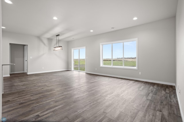 unfurnished living room featuring baseboards, recessed lighting, and dark wood-style flooring
