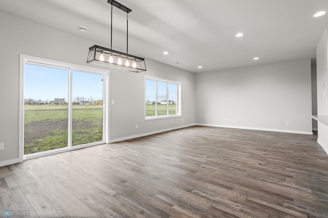 unfurnished dining area featuring baseboards, recessed lighting, and dark wood-style floors
