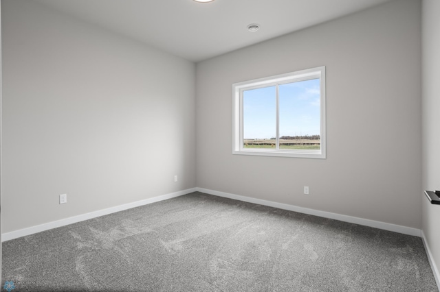 spare room with baseboards and carpet flooring