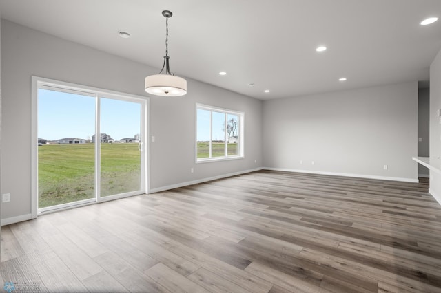 unfurnished dining area with recessed lighting, baseboards, and wood finished floors